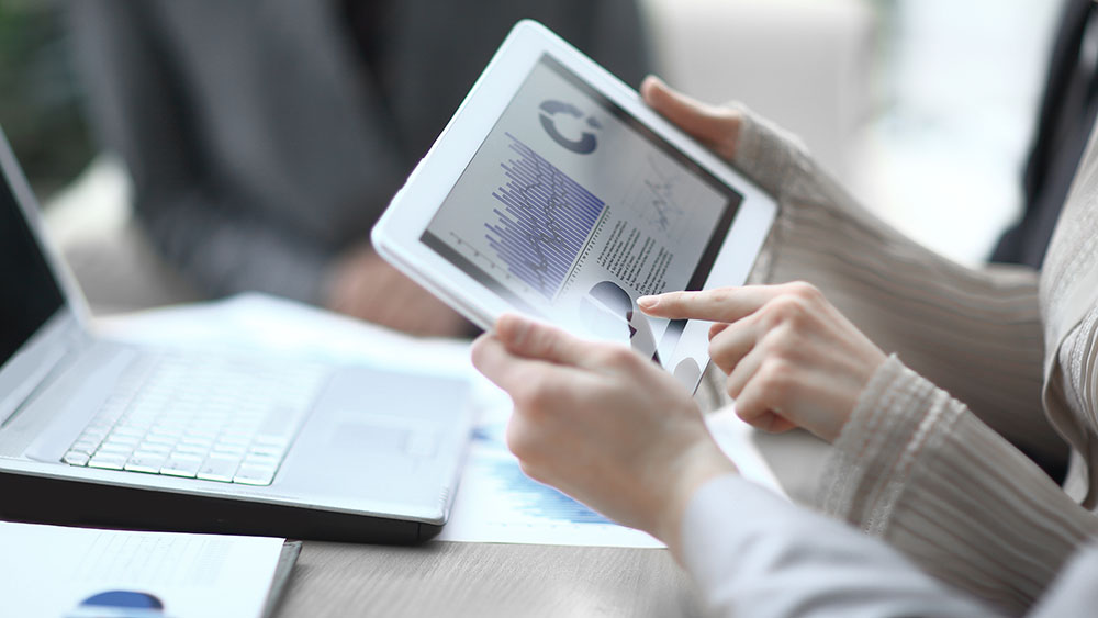 Business team validating financial data on tablet