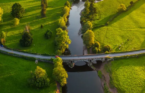 Drone view of a river cutting across a green countryside landscape