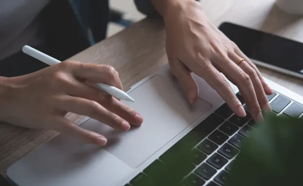 Close up of woman's hands working on a laptop