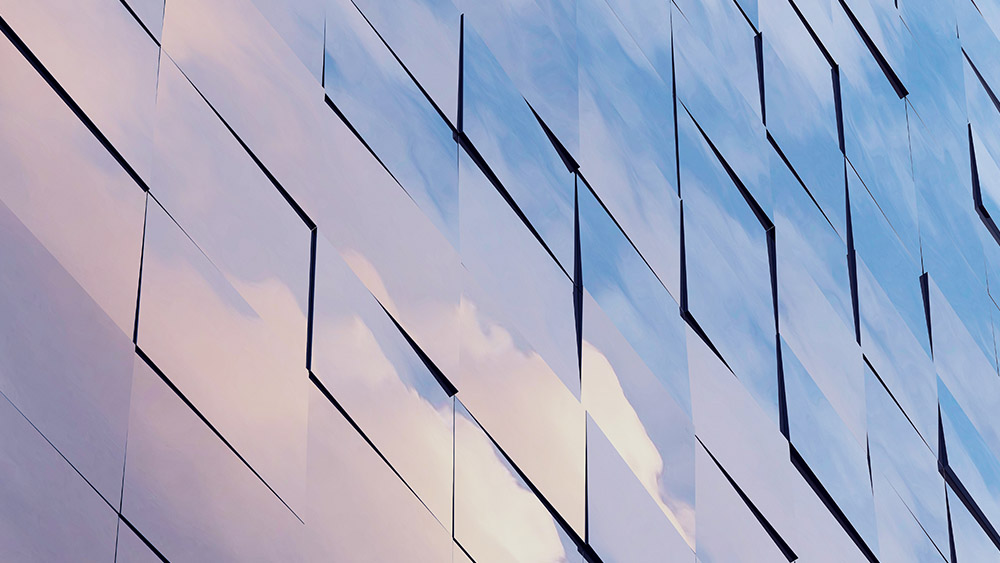 Kuvituskuvassa lasiseinä, jonka moduuleihin heijastaa pilvet taivaalta
