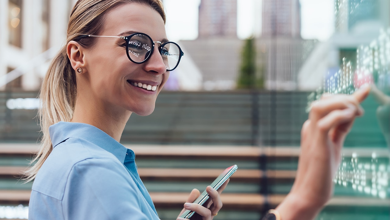 Kunde bruker mobiltelefon og interaktiv skjerm for en personlig digital opplevelse Kunde bruker mobiltelefon og interaktiv skjerm for en personlig digital opplevelse