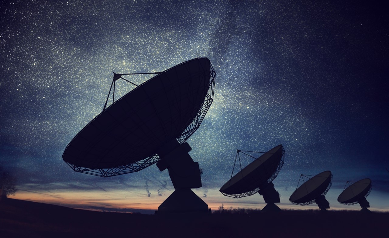A group of satellite dishes in a field