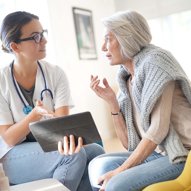 Nurse discussing with older patient_238385681