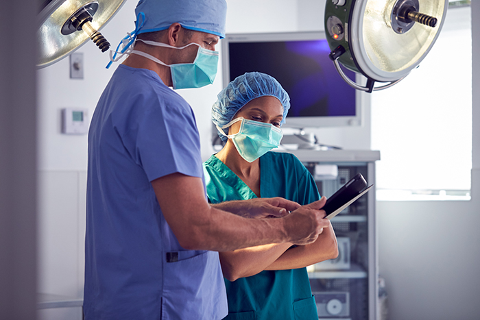medical professionals standing together looking at a tablet 