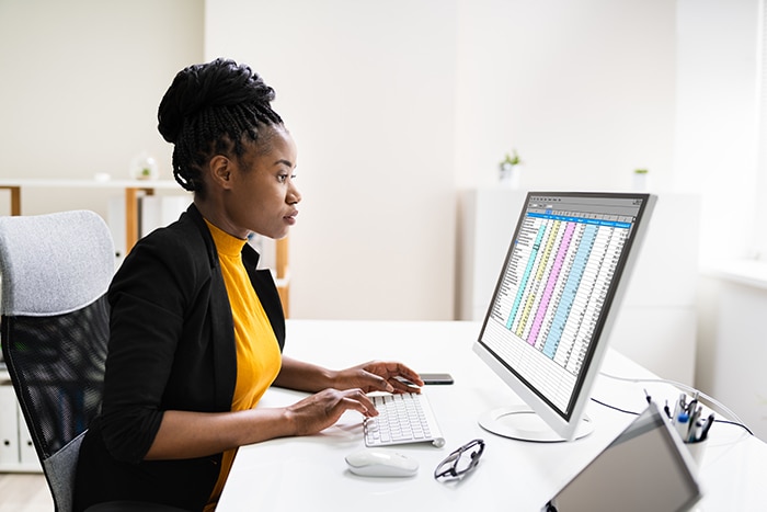 woman working at a computer with a screen full of data