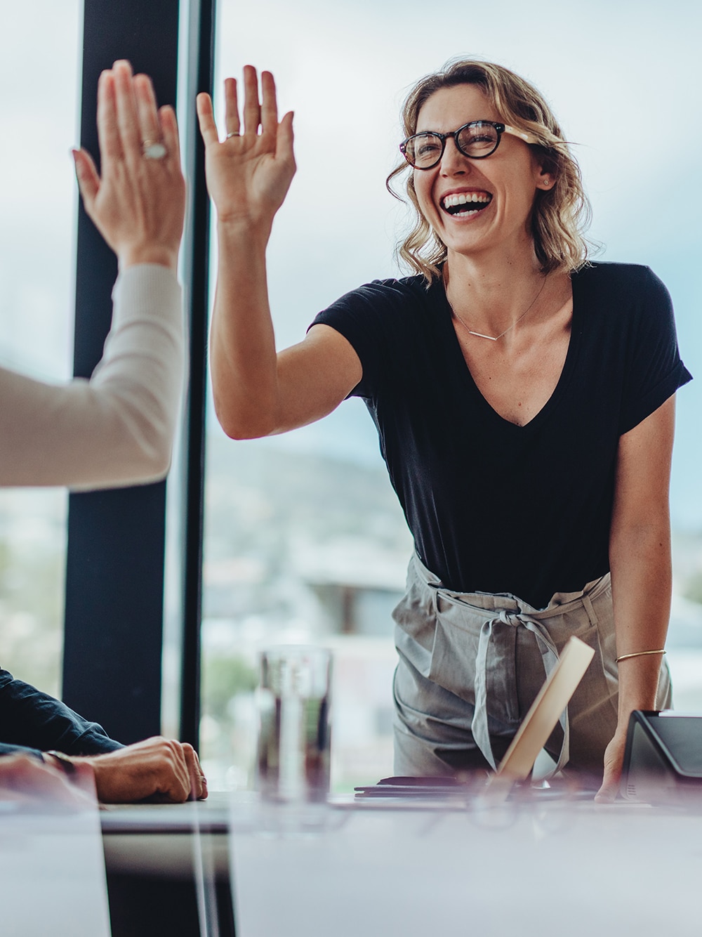 Kuvituskuva: Iloinen nainen heittää läpyt tiimikaverin kanssa