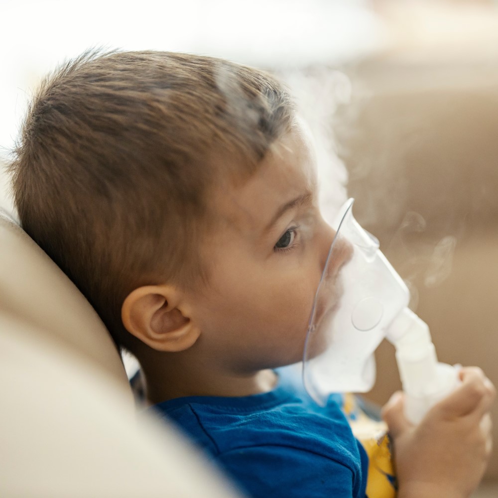Lapsi käyttää hengityslaitetta kotona