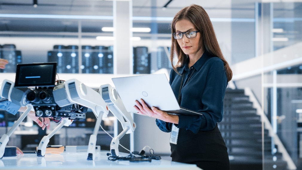Engineer with laptop and robot