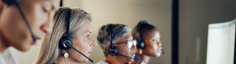 Équipe de conseillers portant des casques et travaillant devant des écran Équipe de conseillers portant des casques et travaillant devant des écran