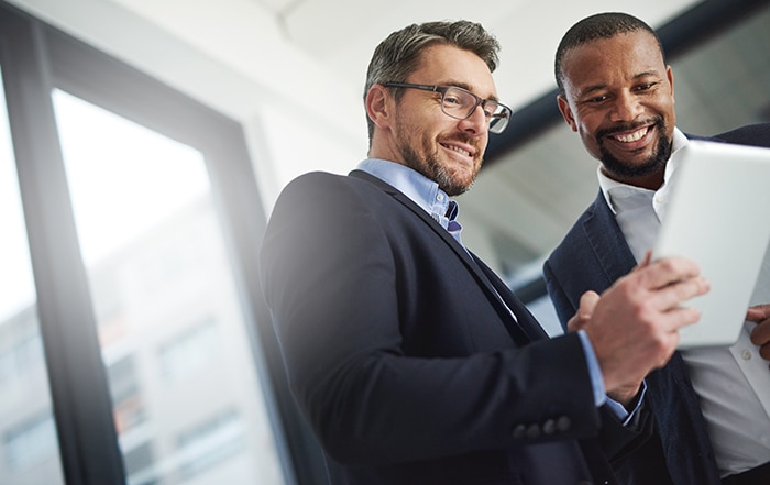 two professionals looking at a notebook and smiling