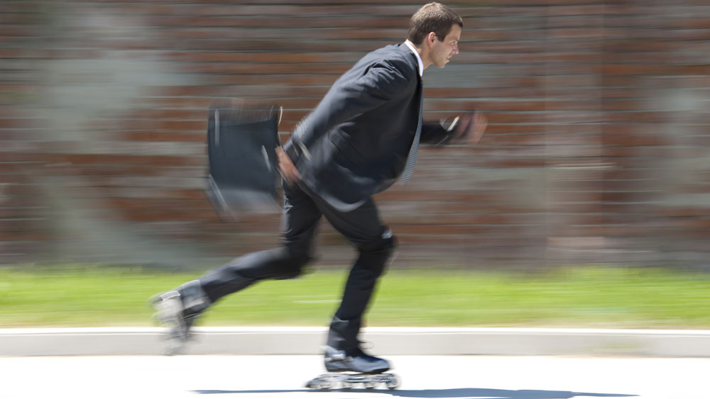 Business man on skates shows agility enroute to work