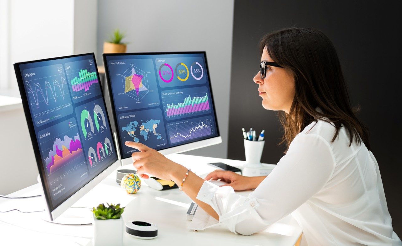 professional working at computer with lots of data on screen