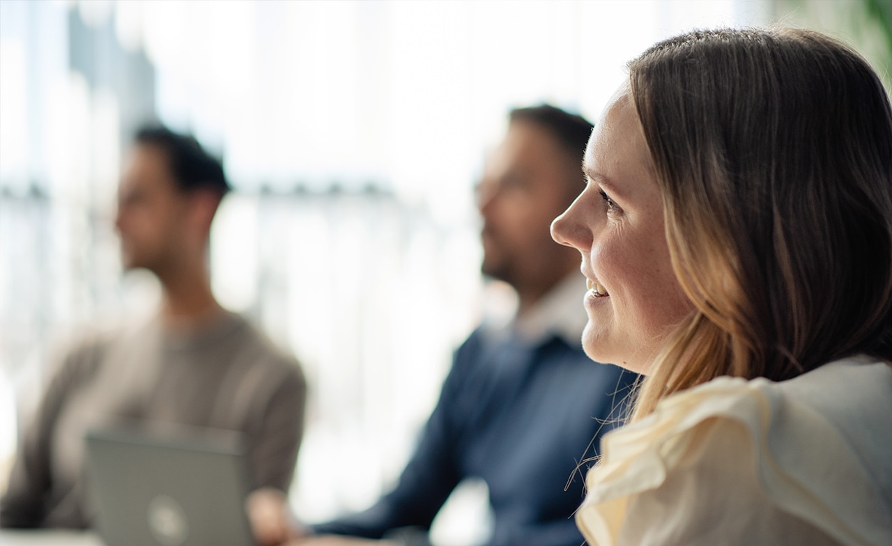 Kvinne som deltar i arbeidsmøte med kollegaer