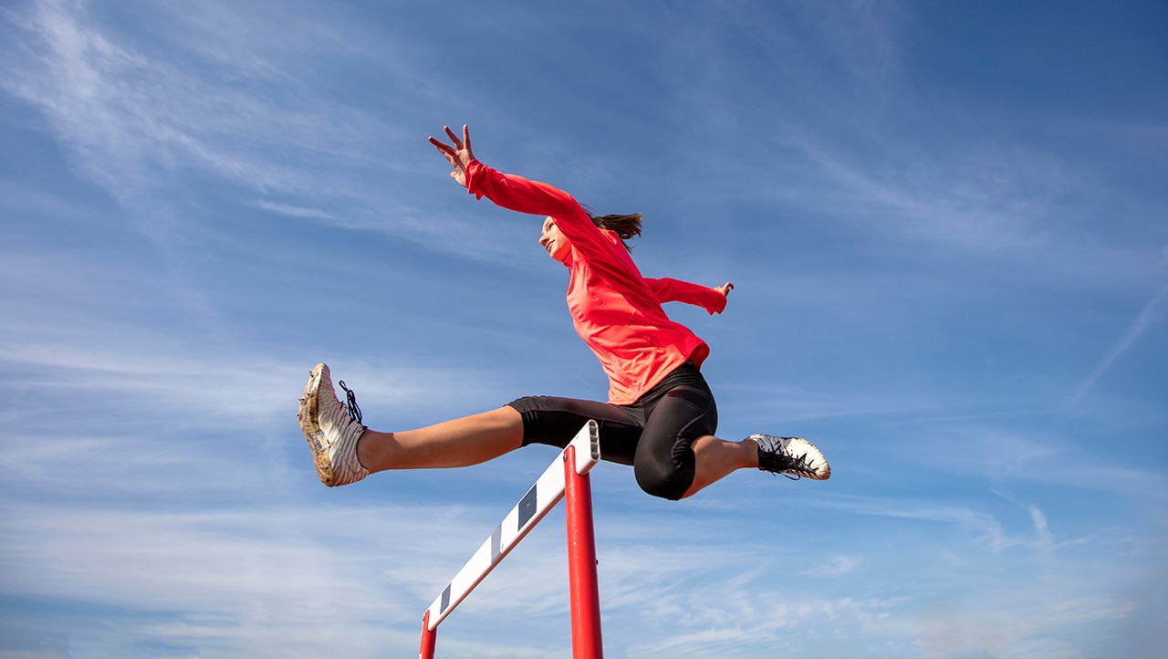 Kvinne hopper i hekkeløp