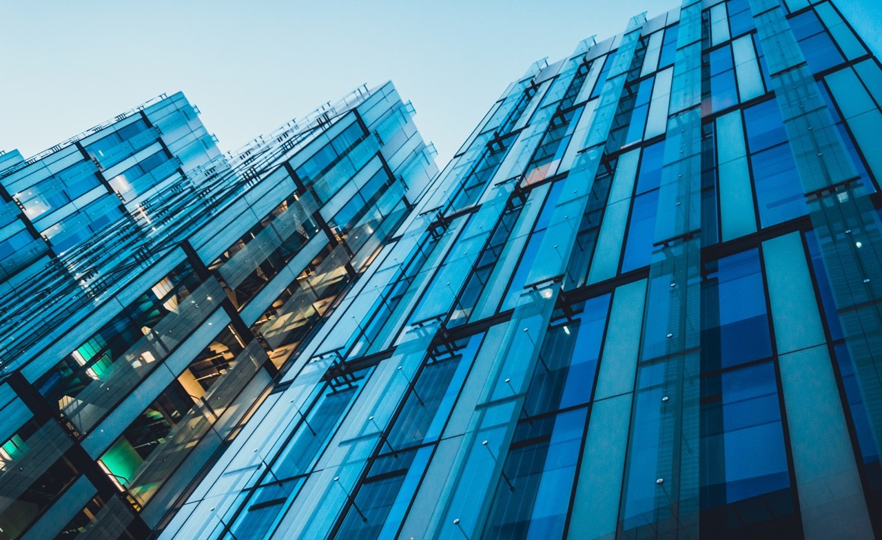 Upward-looking view of modern glass office building
