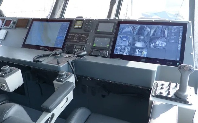 Interior helm of a high-speed boat with multiple screens, gauges, and control panels Interior helm of a high-speed boat with multiple screens, gauges, and control panels