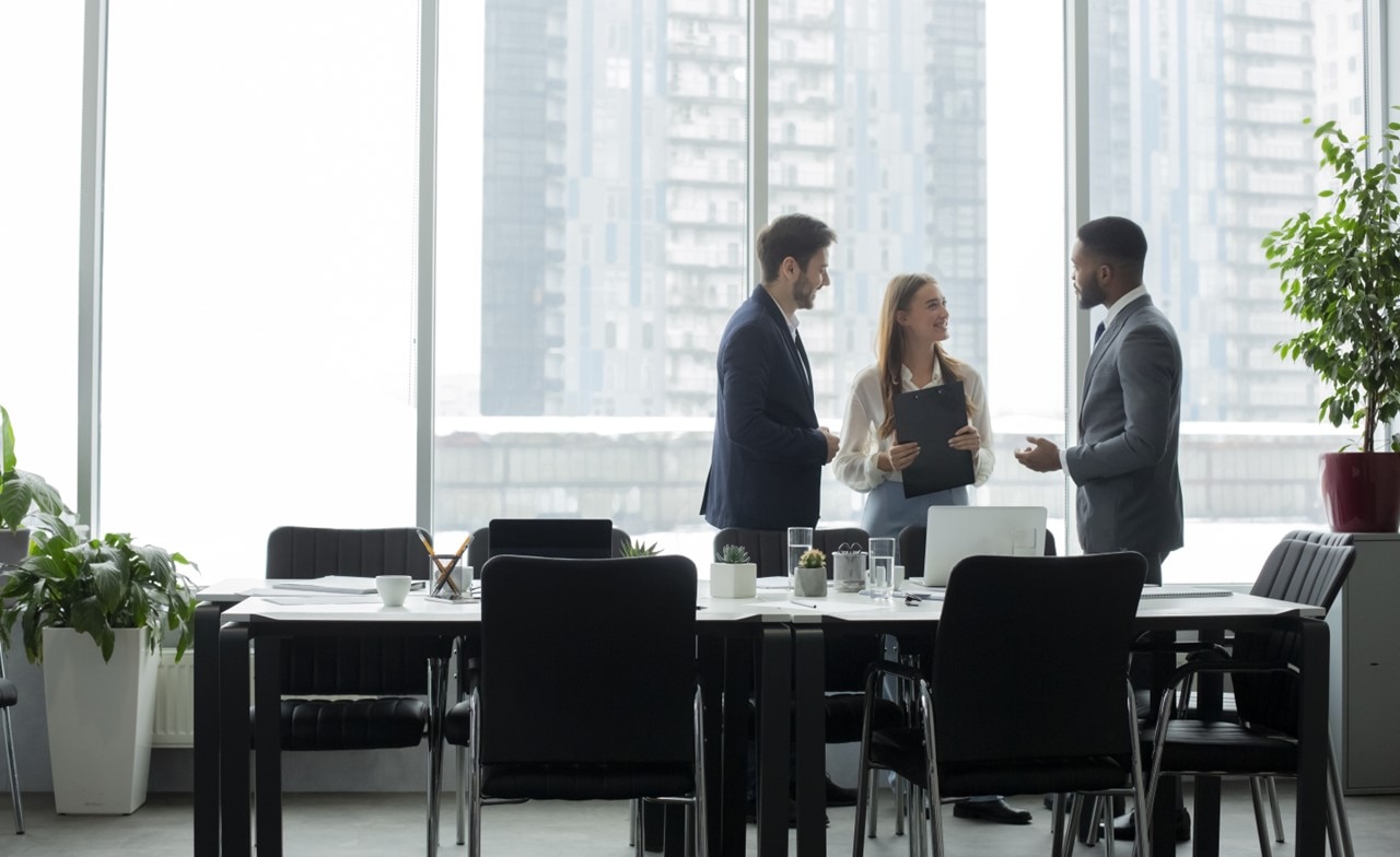 colleagues standing around a table colleagues standing around a table