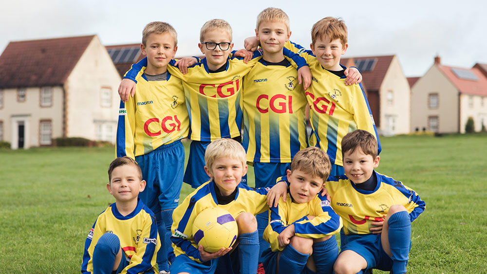 Young boy's football team posing for a photo in their CGI sponsored kit