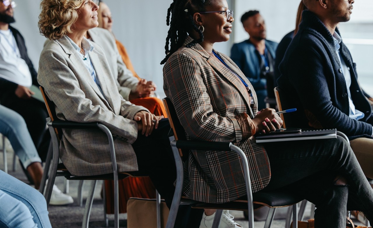 A conference audience sitting and listening to a presentation