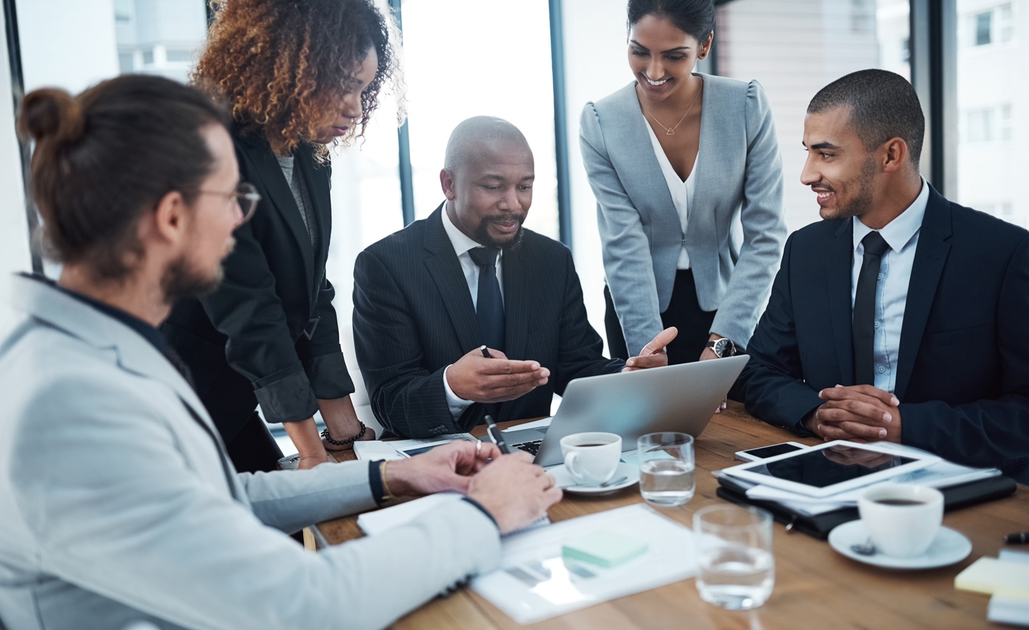 Réunion de consultants autour d'une table et d'un ordinateur portable Réunion de consultants autour d'une table et d'un ordinateur portable