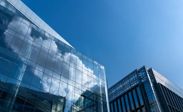 Wolken spiegeln sich in einer Glasscheibe eines Bürokomplexes Wolken spiegeln sich in einer Glasscheibe eines Bürokomplexes