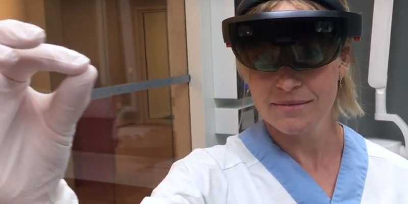En tandsköterska med VR-glasögon kniper med fingrarna om något som vi inte ser i bild