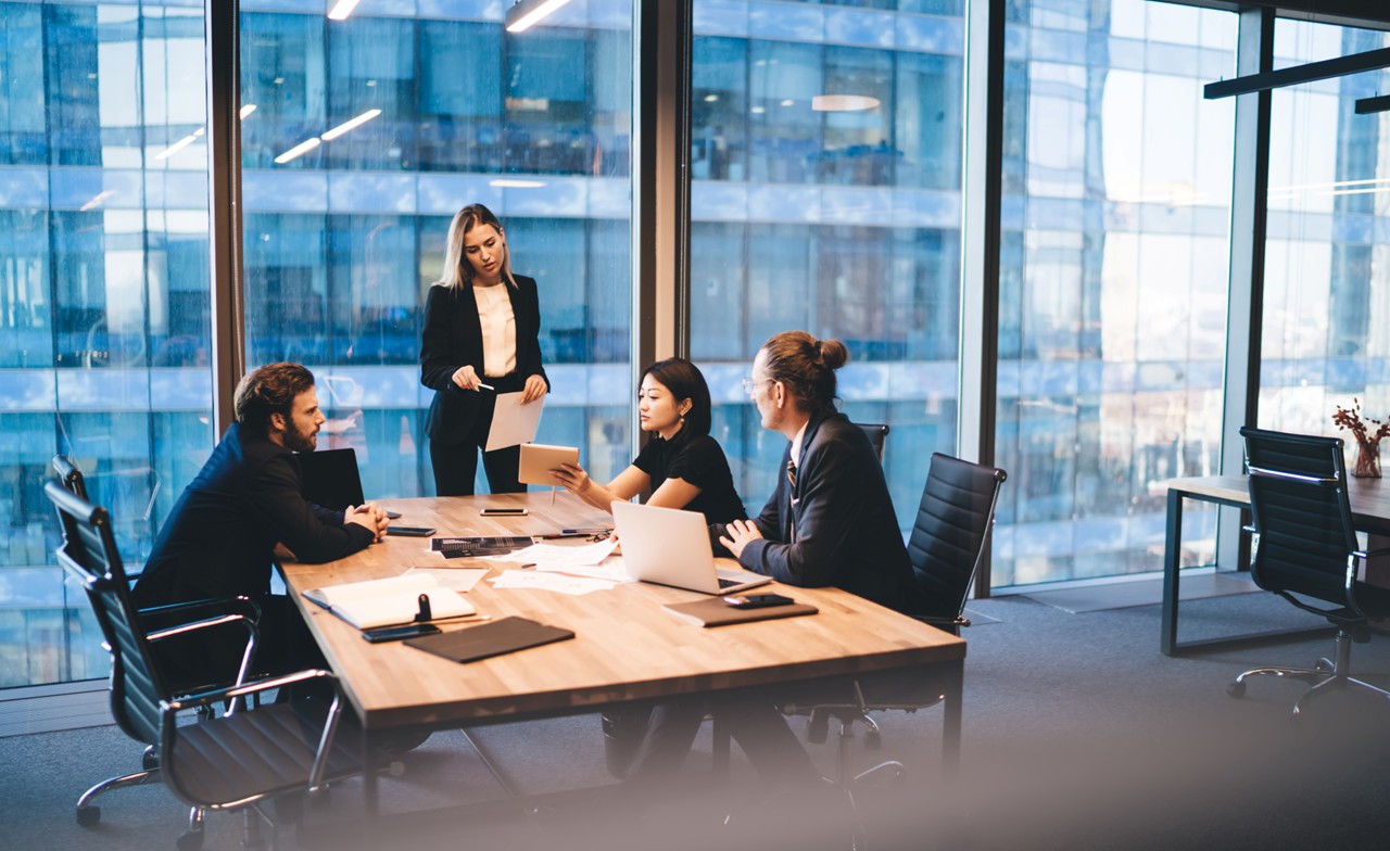 Arbeitsbesprechung zur Weiterentwicklung eines Managed SOC in einem modernen Konferenzraum