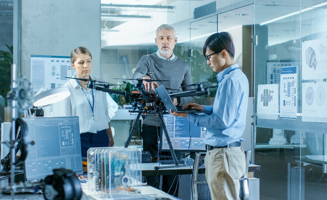 Engineers work with new drone in a lab setting