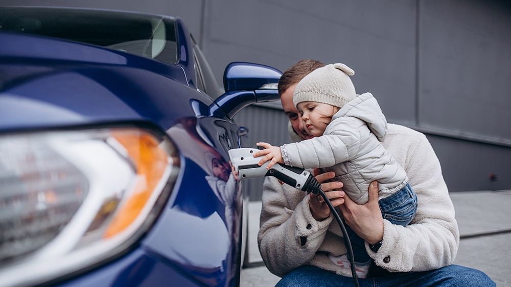 father and child plugging in ev