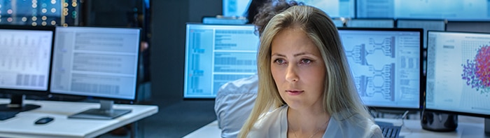 woman working in lab with computers with data on screens