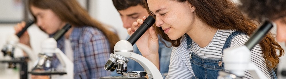 Girl looks into microscope
