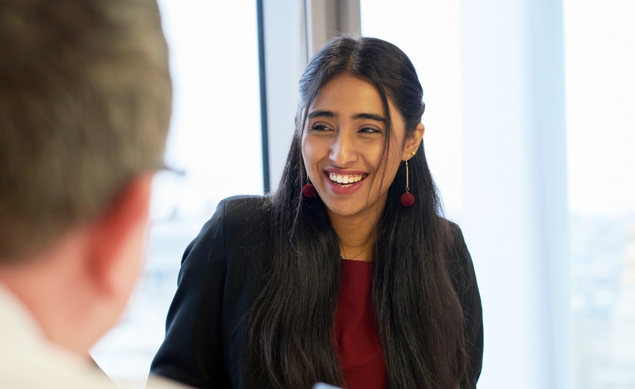 Kuvituskuva: nainen hymyilee toimistolla.