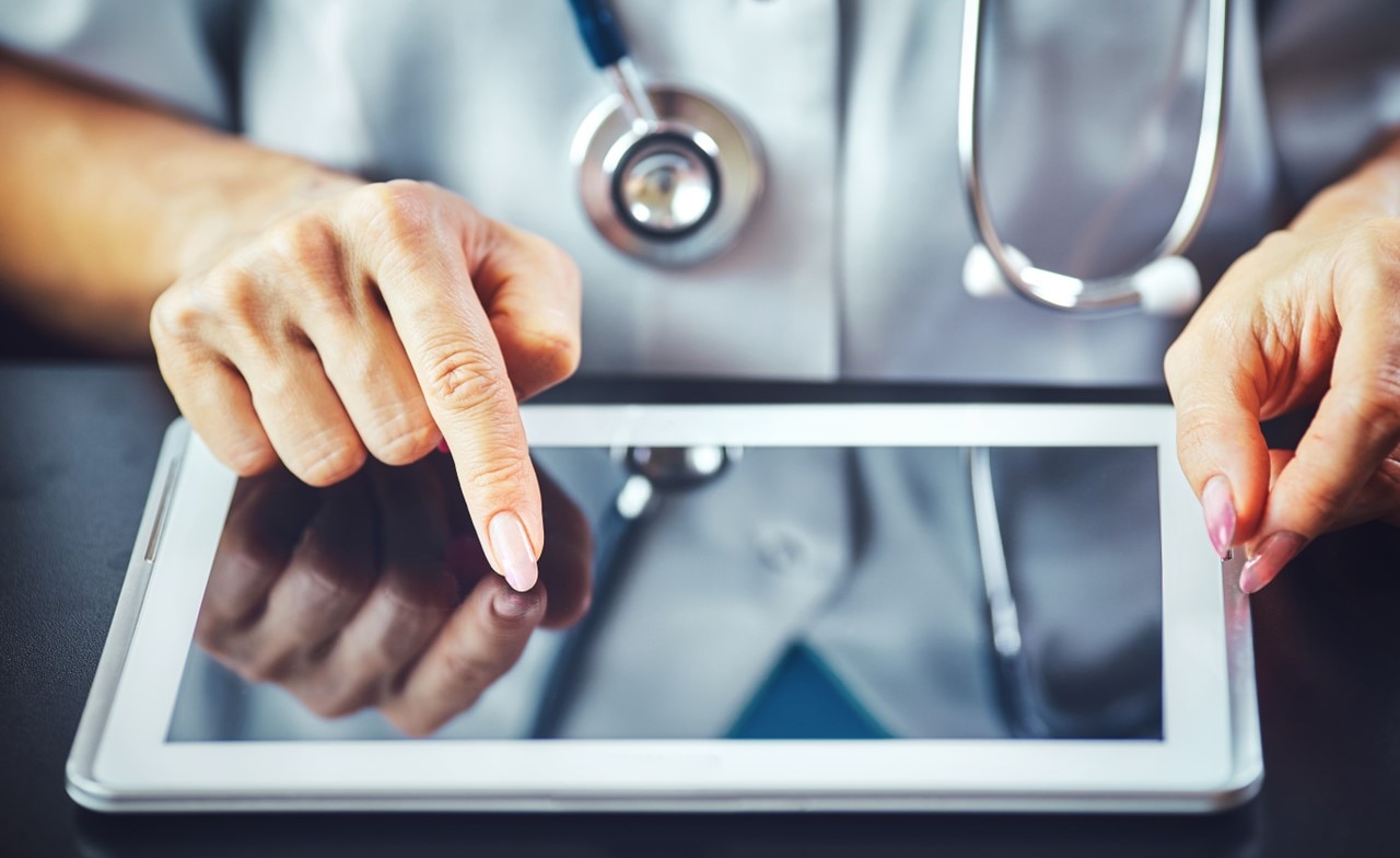 Professionnel de santé à deux mains à l’aide d’une tablette