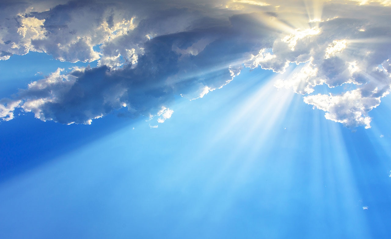 Sunrays through clouds - blue sky