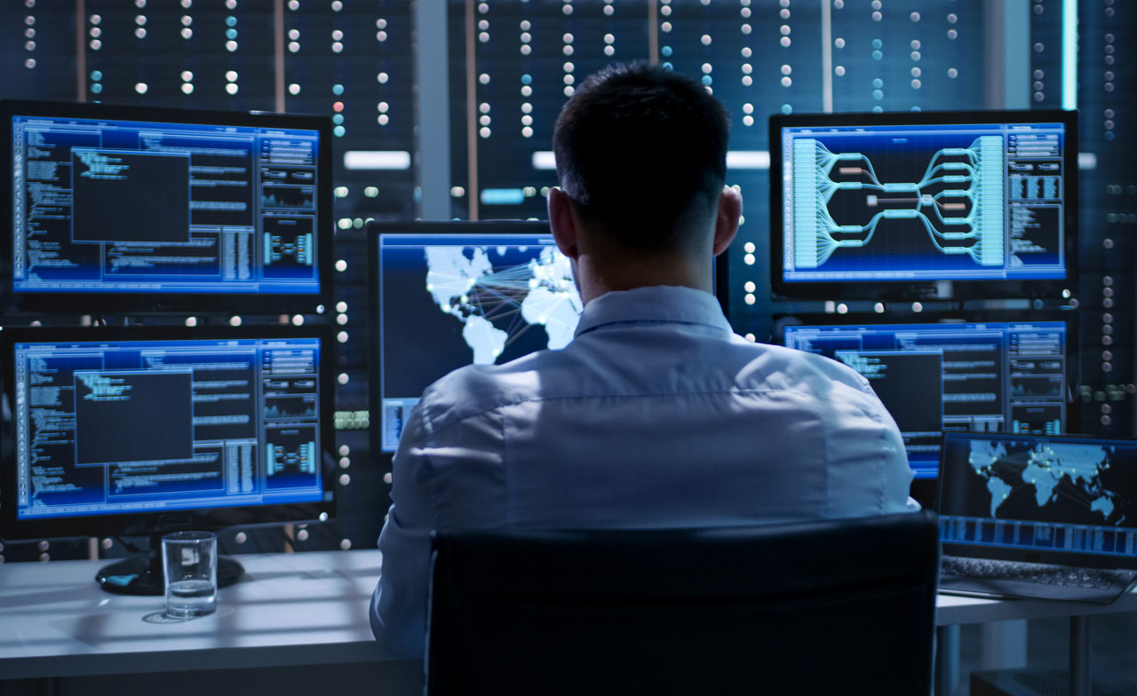 Geospatial analyst looking at data on multiple screens
