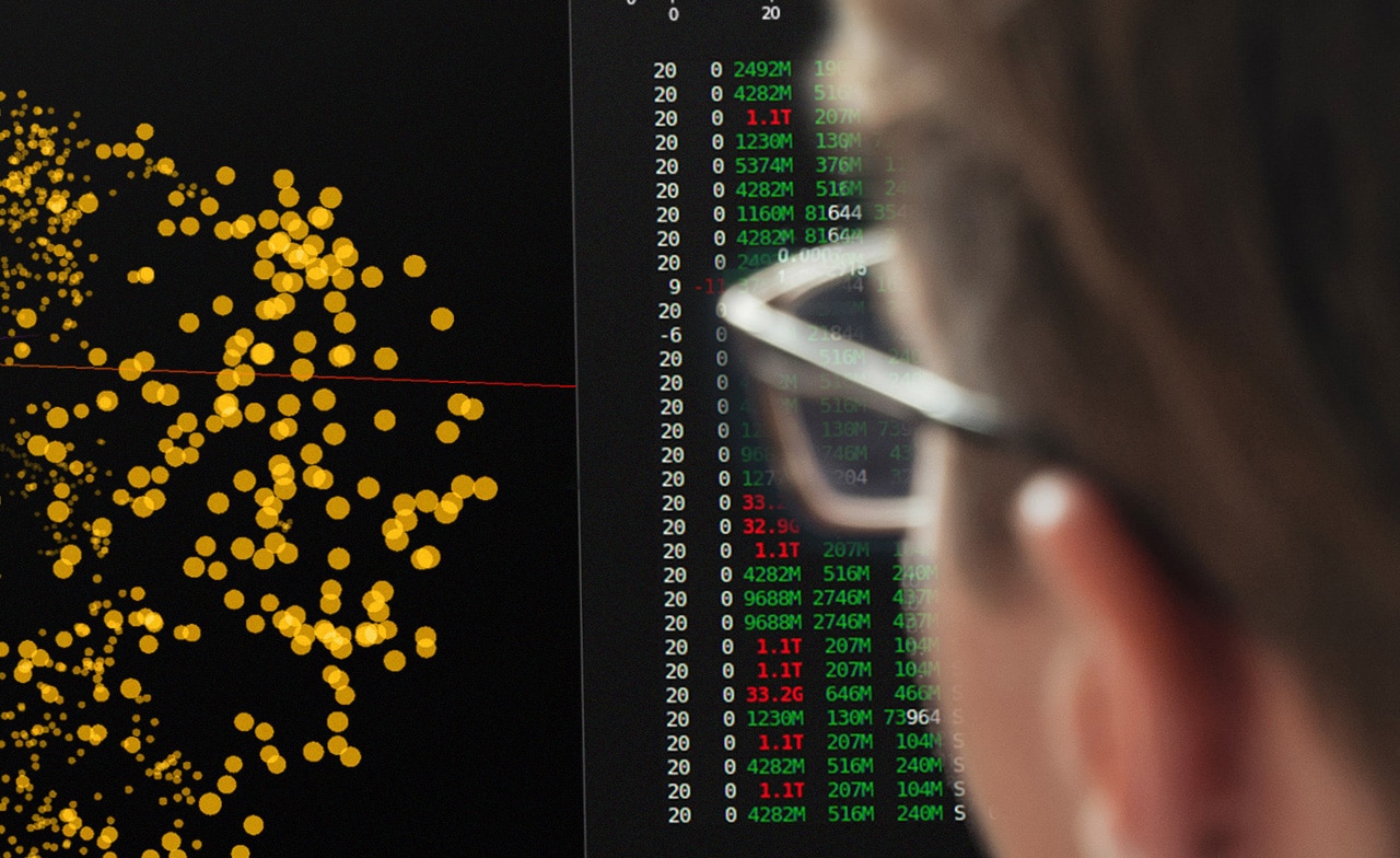 Person ser på skjerm med datavisualisering og tallkolonner. Person ser på skjerm med datavisualisering og tallkolonner.