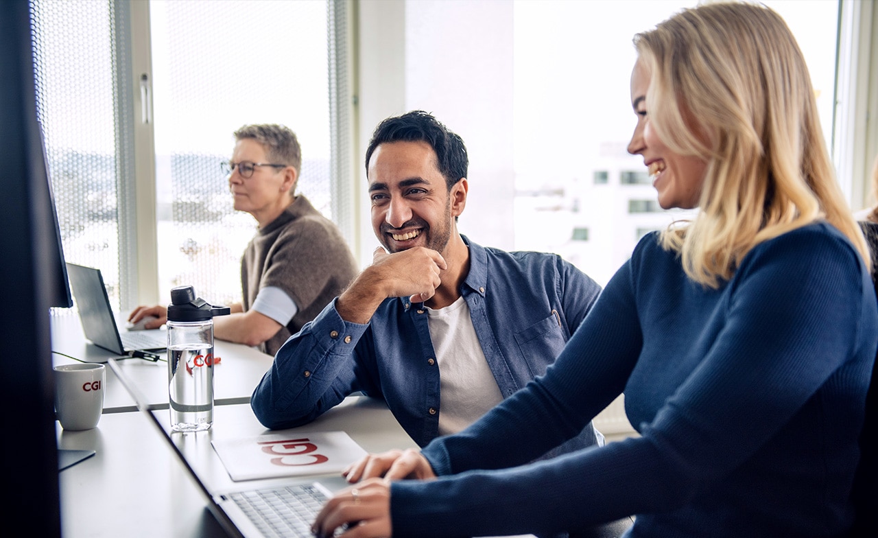 Fachpersonen arbeiten gemeinsam an digitalen Lösungen als Symbol für agile Zusammenarbeit und Co-Creation in der IT-Transformation.