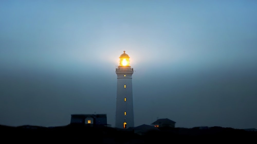 A lighthouse and surrounding buildings at night