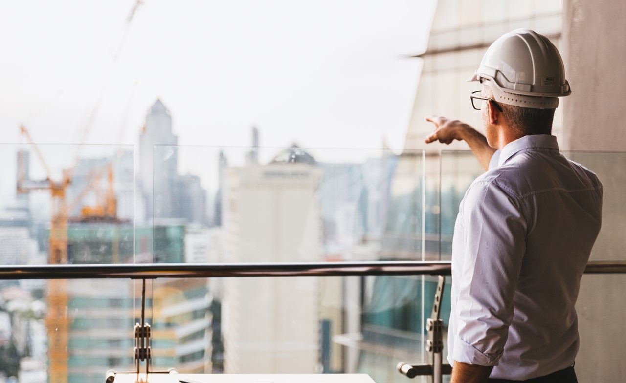 Male engineer wearing safety helmet looking at construction site