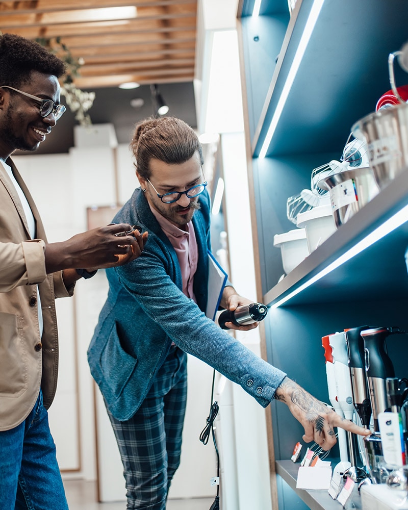 Kuvituskuva: Myyjä keskustelemassa asiakkaan kanssa myymälässä keittiön pienkoneista