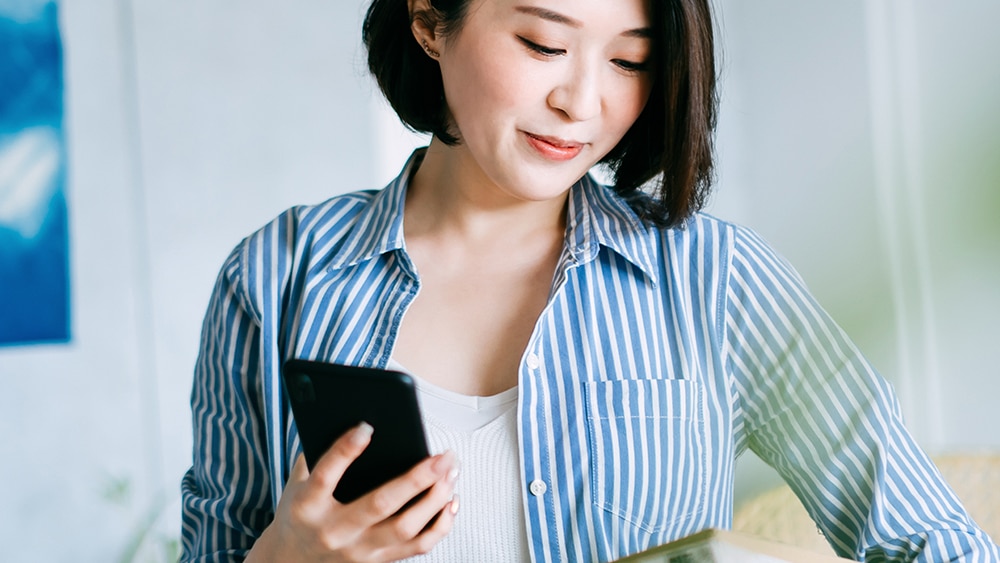 Femme avec un smartphone pour illustrer la valeur ajoutée du retail