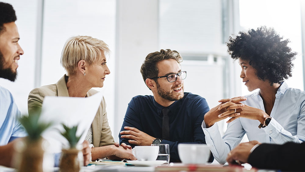 four people having discussion around table