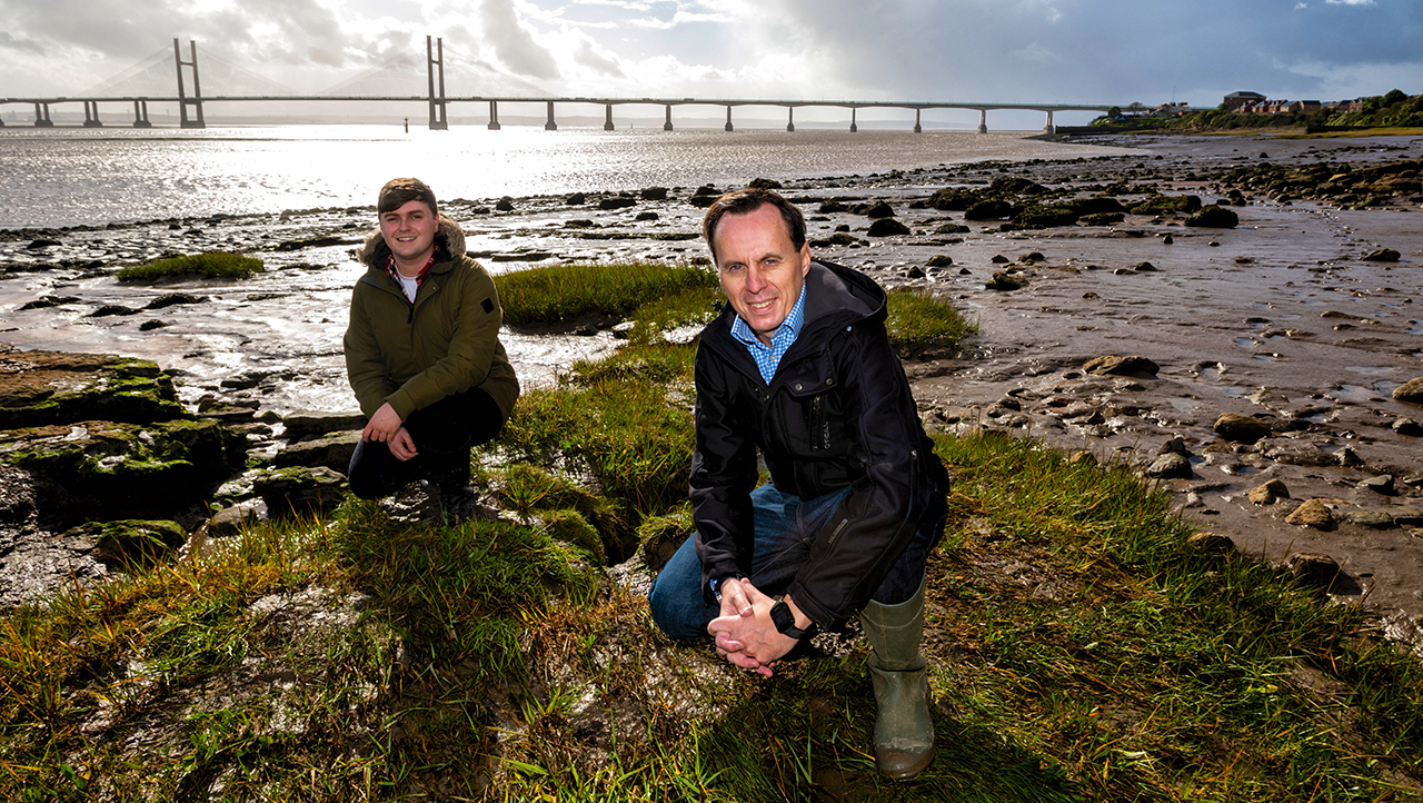Two men crouching in the severn estuary