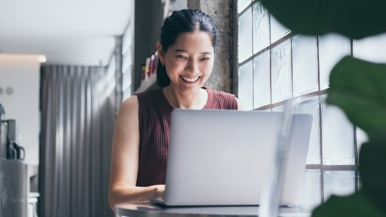 woman smiling and working at laptop