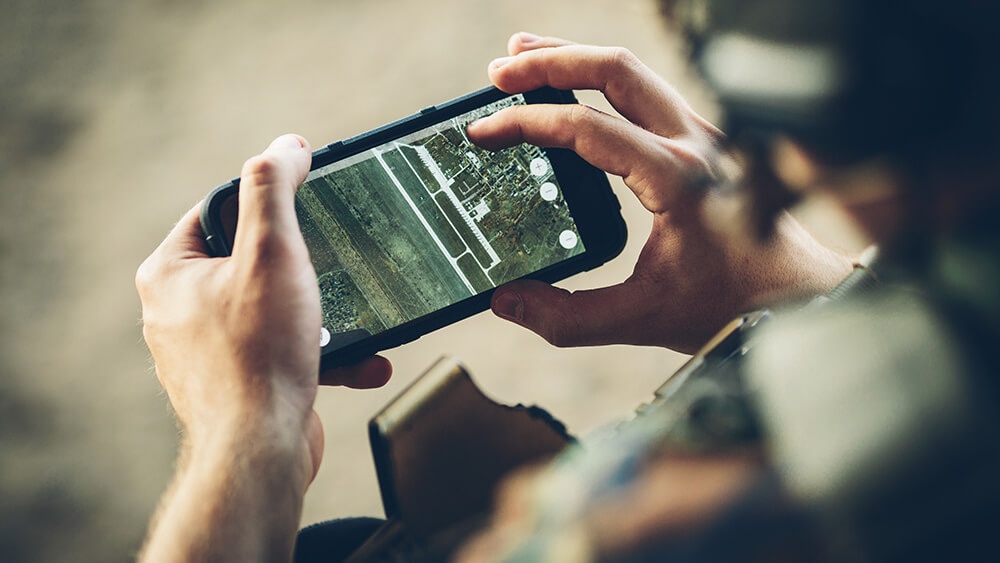 A military man looking at a smartphone medium A military man looking at a smartphone