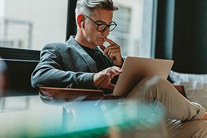 a man looking at a computer that is on his lap