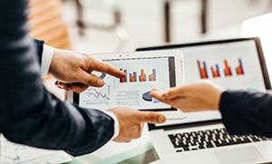 professionals looking at data on computer and tablet