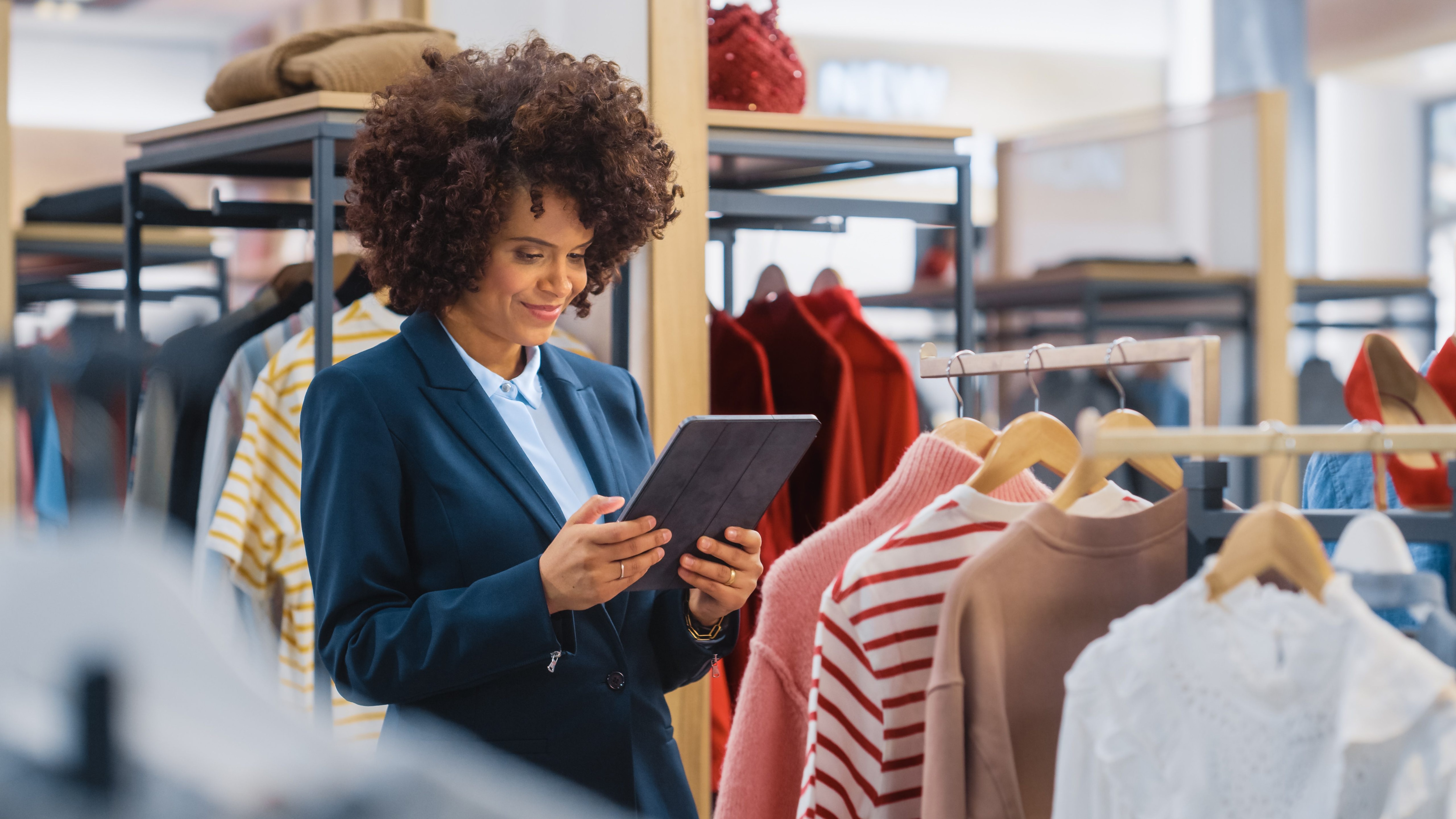 retail shopper uses tablet device in clothes store