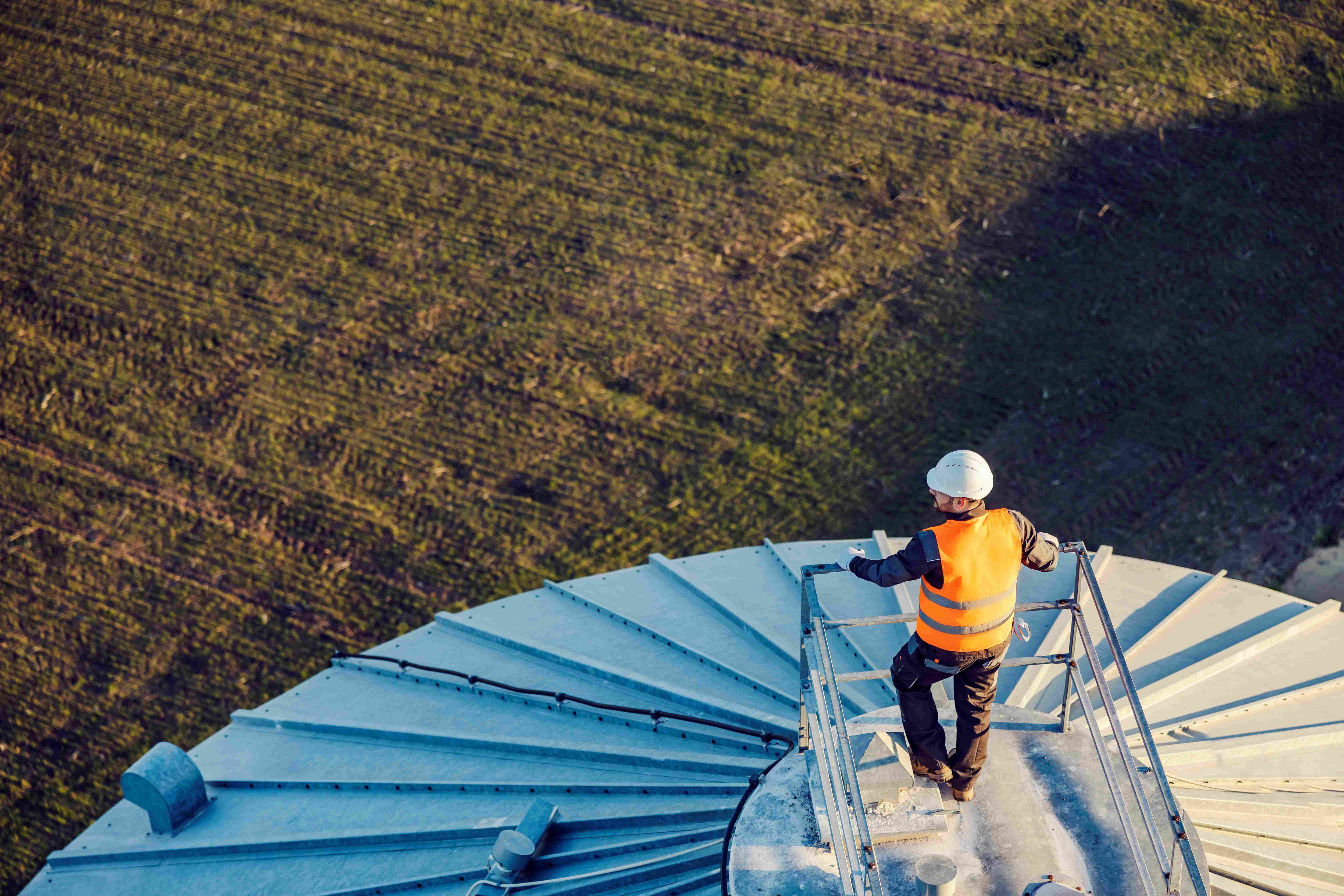 Aerial view of an industry worker standing on top of the silo