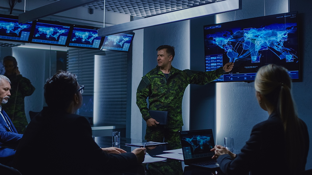 military personnel look at map in mission control room 